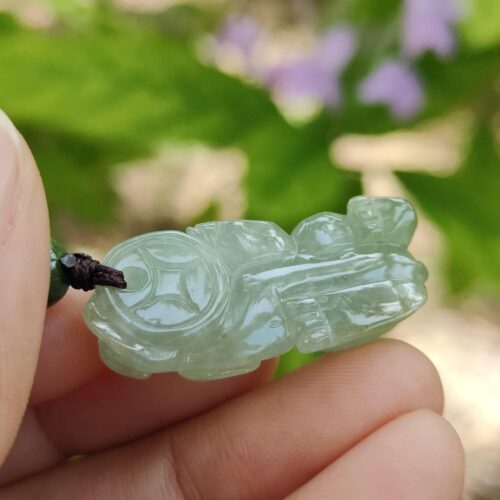 翡翠のペンダントを持つ手