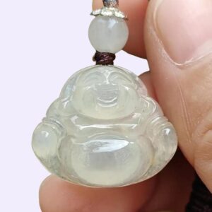 a hand holding a jade pendant