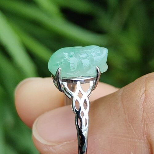 tangan memegang cincin dengan batu giok