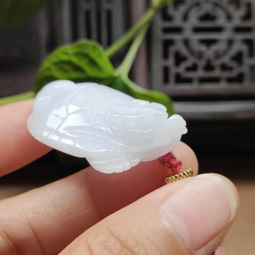 Una mano sosteniendo un colgante de jade.