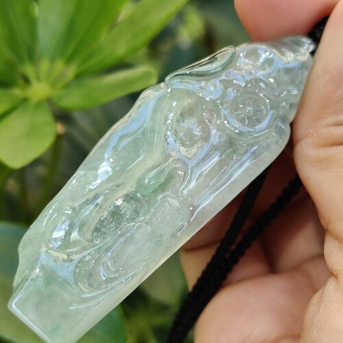 a hand holding a jade necklace