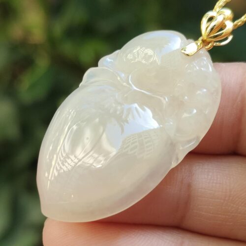 一只手拿着白玉吊坠