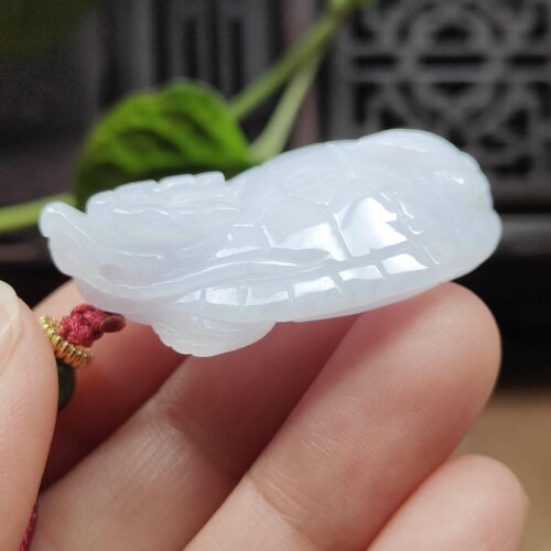 Una mano sosteniendo un colgante de jade.