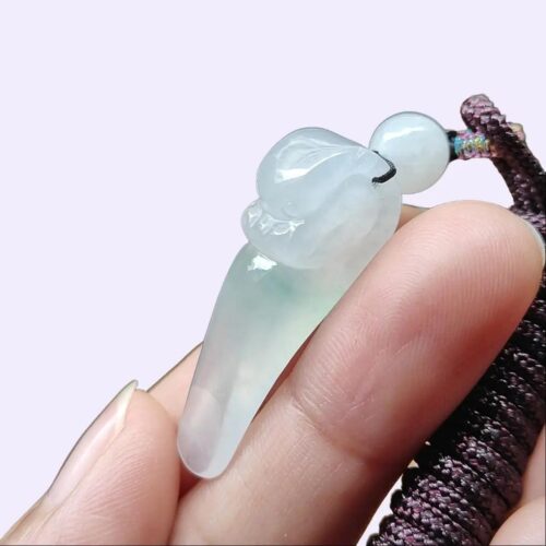 a hand holding a jade pendant