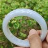 Una mano que sostiene un objeto circular blanco.