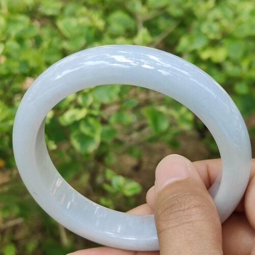 Una mano que sostiene un objeto circular blanco.