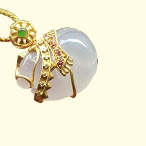 liontin emas dengan batu putih dan permata hijau