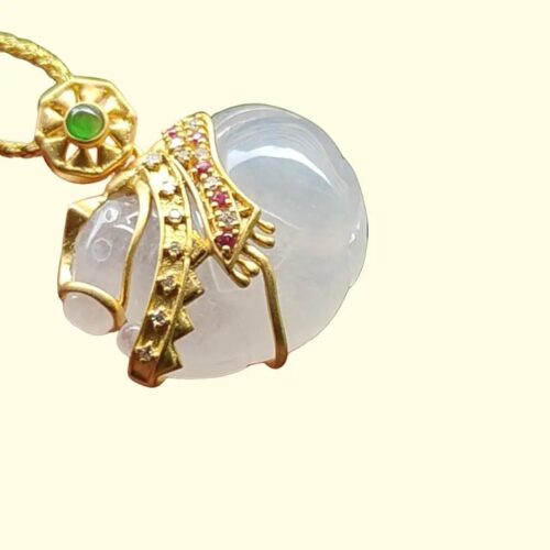 một mặt dây chuyền vàng với một viên đá trắng và một viên ngọc xanh