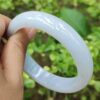 una mano sosteniendo una pulsera blanca