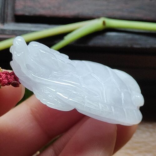 Una mano sosteniendo un objeto de jade blanco.