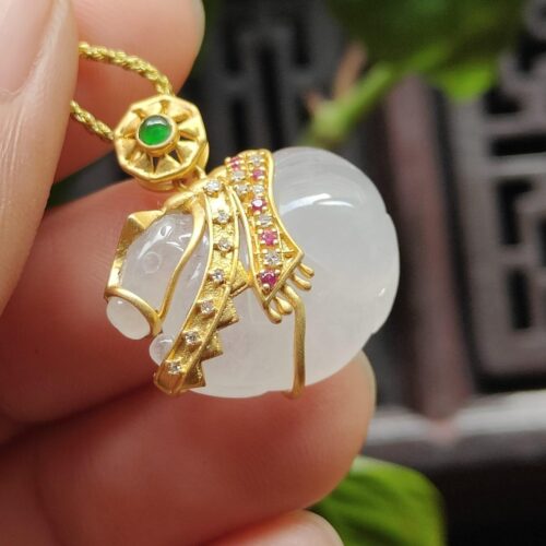 một bàn tay cầm một mặt dây chuyền vàng