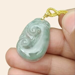 Una mano sosteniendo un colgante de jade.