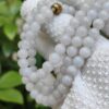 a white beaded necklace on a white cloth