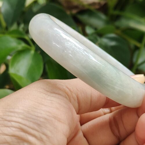 a hand holding a white bracelet