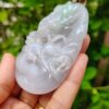 a hand holding a jade pendant