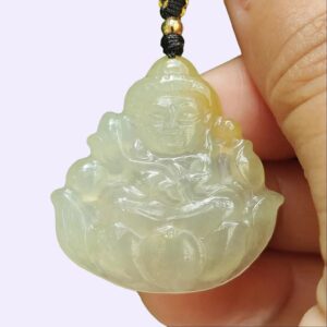 a hand holding a jade pendant