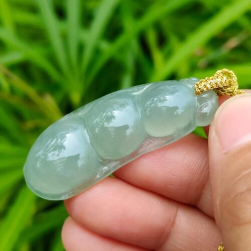 a hand holding a jade necklace