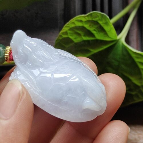 Una mano sosteniendo un colgante de jade.