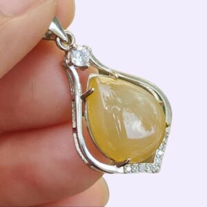 une main tenant un pendentif