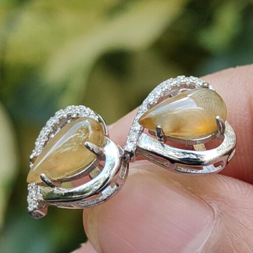 a hand holding a pair of earrings