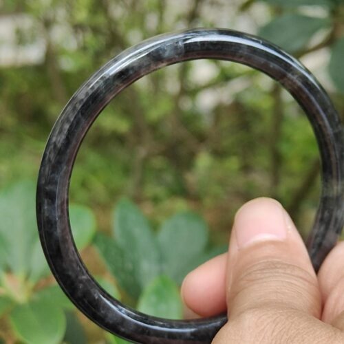 a hand holding a black ring