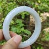 Una mano que sostiene un objeto circular blanco.