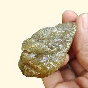 a hand holding a piece of green stone