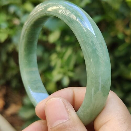 a hand holding a green bracelet