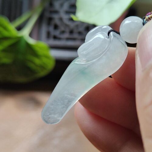 a hand holding a jade necklace