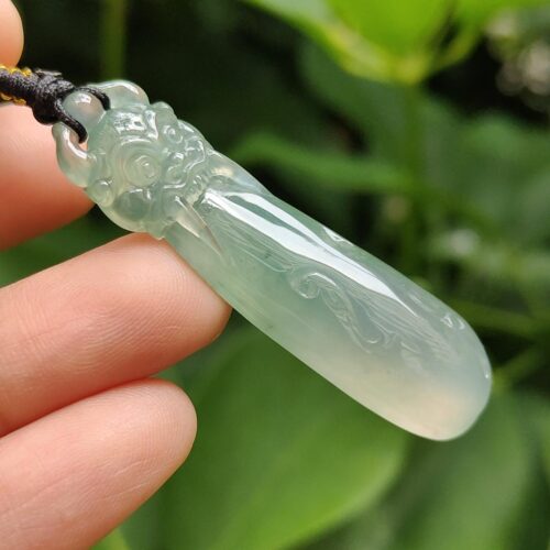 Una mano sosteniendo un colgante de jade.