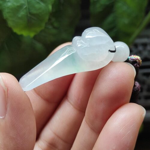 a hand holding a jade object