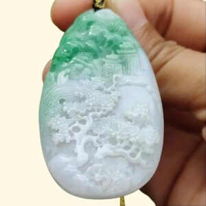 a hand holding a jade pendant