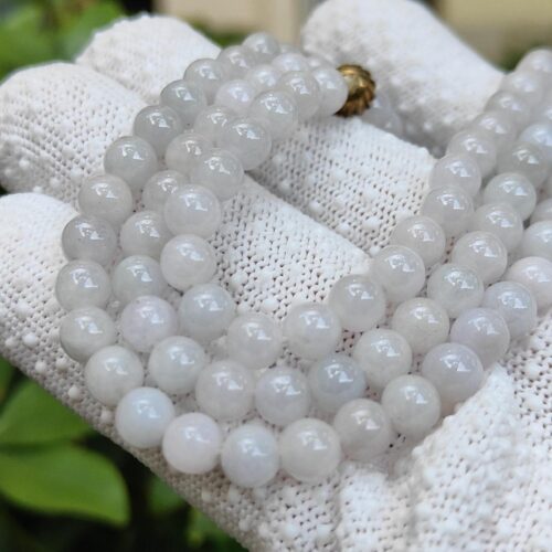 a hand wearing a glove with a necklace