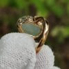 a hand holding a gold ring
