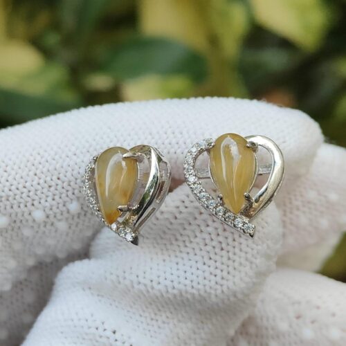 a pair of earrings on a white cloth