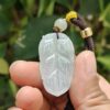 a hand holding a jade pendant