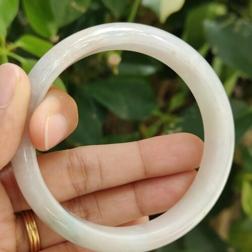 a hand holding a white circular object