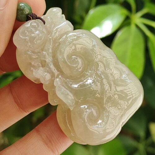 Una mano sosteniendo un colgante de jade.