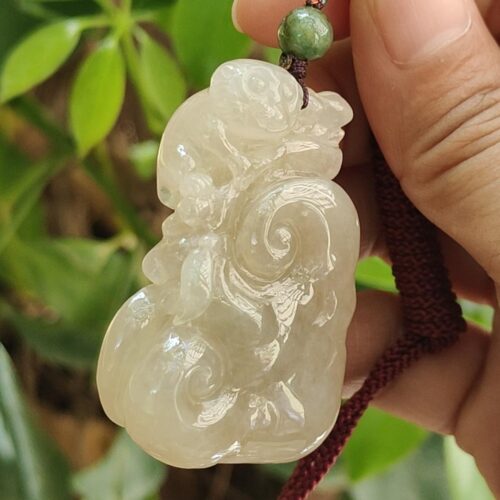 Una mano sosteniendo un colgante de jade.