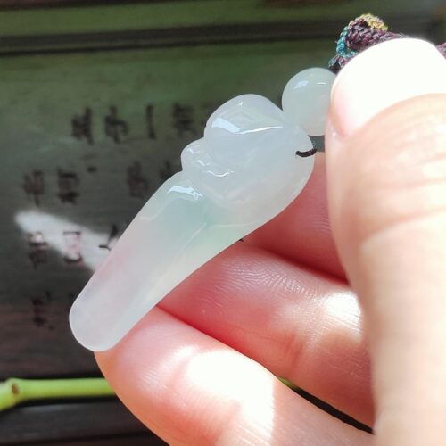 a hand holding a jade object