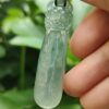 Una mano sosteniendo un colgante de jade.