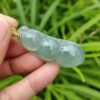 a hand holding a jade necklace