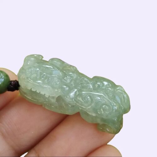 翡翠のペンダントを持つ手