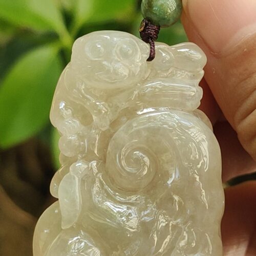 Una mano sosteniendo un colgante de jade.