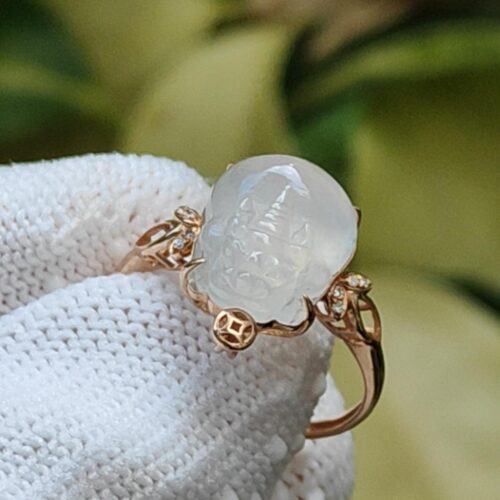 கையுறை அணிந்த ஒரு கை மோதிரத்தை வைத்திருக்கும்