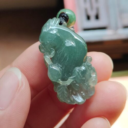 tangan memegang liontin giok