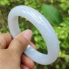 una mano sosteniendo una pulsera blanca
