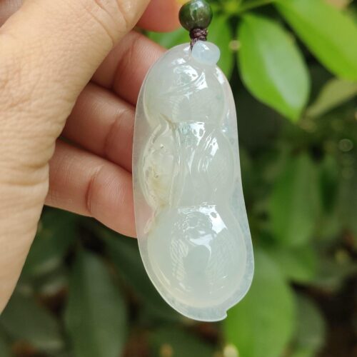 a hand holding a jade pendant - Bean with Bat