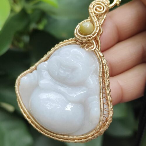 a hand holding a jade pendant - Milo Buddha