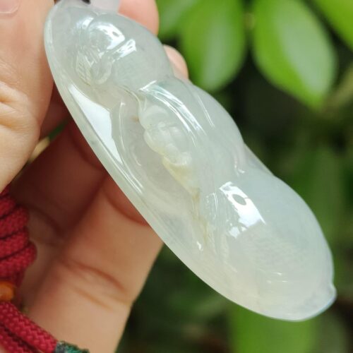 a hand holding a jade pendant - Bean with Bat